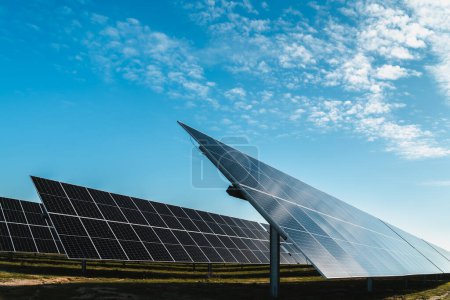 Téléchargez les photos : Côté de la rangée de panneaux solaires dans la centrale solaire photovoltaïque, journée ensoleillée - en image libre de droit