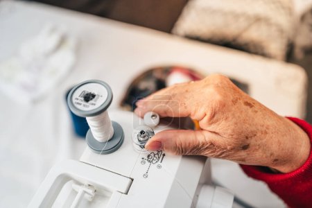 Photo for Detail of senior woman hands preparing sewing machine - Royalty Free Image