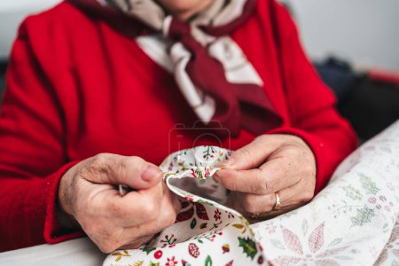 Téléchargez les photos : Détail des mains de couturière lors de la couture d'un tissu avec des fils - en image libre de droit