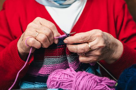 Foto de Foto horizontal de cerca de las manos de las mujeres mayores cosiendo con lana y agujas - Imagen libre de derechos