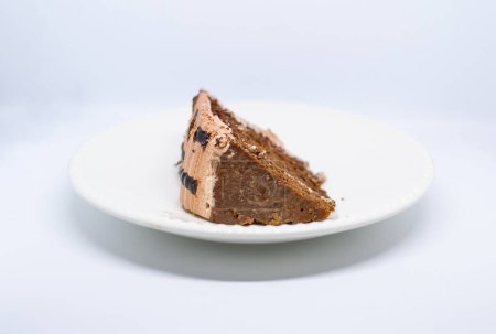 Foto de Un pedazo de pastel con chocolate y crema en un plato blanco. - Imagen libre de derechos