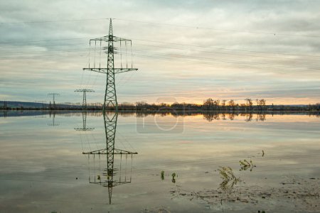 Foto de Líneas de alta tensión y pilones reflejados en el agua. - Imagen libre de derechos