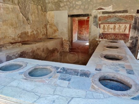 Photo for Pompeii, Campania, Italy - October 14, 2021: House and Thermopolium of Vetutius Placidus in Via dell'Abbondanza in the Archaeological Park of Pompeii - Royalty Free Image
