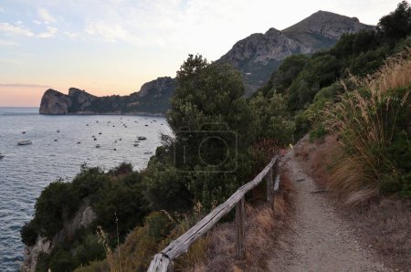 Photo for Marina del Cantone - 4 September 2023: Panorama of the coast from the path that connects the Marina del Cantone beach with the Recommone beach at sunset - Royalty Free Image