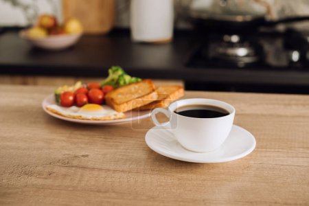 Foto de Copa de café negro y desayuno en el fondo en la cocina en casa - Imagen libre de derechos