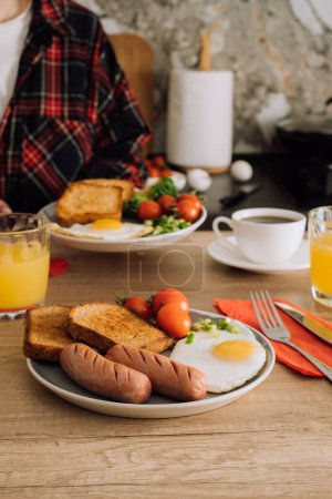 Foto de Desayuno inglés cocinado con café y zumo de naranja en la cocina en casa - Imagen libre de derechos