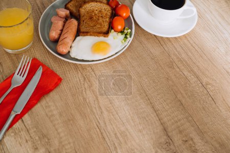 Foto de Desayuno inglés con café negro y zumo de naranja en mesa de madera con espacio para copiar - Imagen libre de derechos