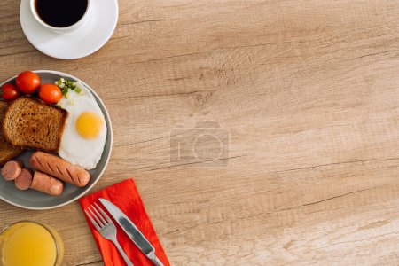Foto de Desayuno inglés con café negro y zumo de naranja en mesa de madera con espacio para copiar - Imagen libre de derechos