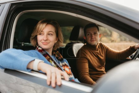Foto de Pareja adulta en viaje de otoño, hombre y mujer sentados en el coche y mirando por la ventana - Imagen libre de derechos