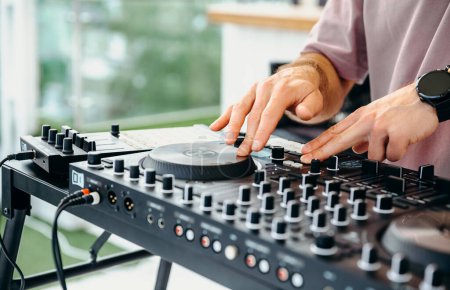 Téléchargez les photos : Mixeur dj et écouteurs sur la table de musique sur fond de mixeur de musique ou mains dj. gros plan des mains d'un DJ moderne ou d'un mix - en image libre de droit