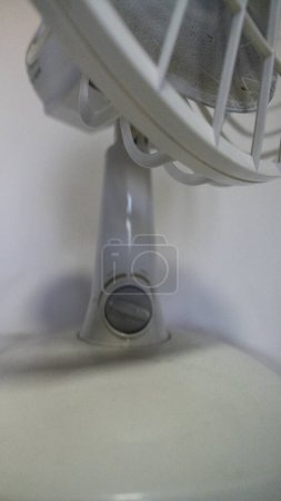 Foto de Pequeño ventilador blanco con reparación de hélice de 4 palas en la mesa - Imagen libre de derechos