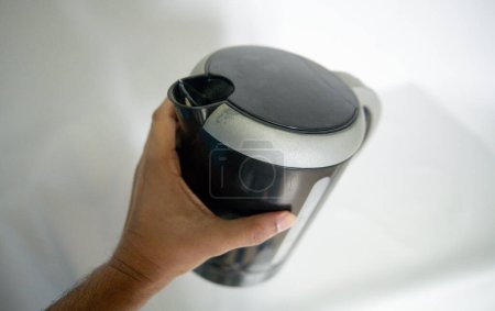 Photo for Hand holding a medium-sized electric kettle - Royalty Free Image