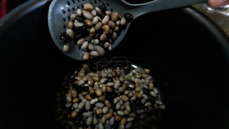 Foto de Frijoles blancos, frijoles negros, frijoles marrones, crudos preparados por dos personas al mismo tiempo - Imagen libre de derechos
