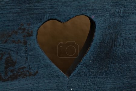 Foto de Un agujero transparente en forma de corazón en una vieja madera azul - Imagen libre de derechos