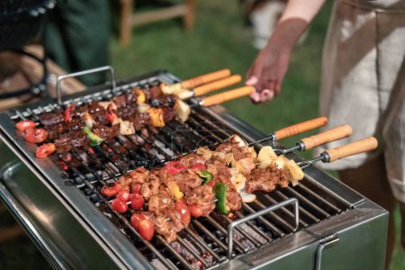 Barbeque skewers beef and pork with vegetable grilling on charcoal bbq grill in backyard on picnic time