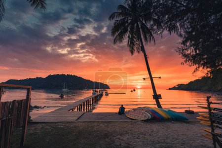 Foto de Beautiful sunset over tropical sea and wooden bridge, sightseeing boat and tourist enjoying in Koh Kood beach, Thailand - Imagen libre de derechos