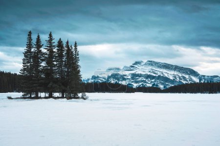 Téléchargez les photos : Belle vue sur le lac Two Jack avec le mont Rundle et la forêt de pins en hiver le soir au parc national Banff, Alberta, Canada - en image libre de droit