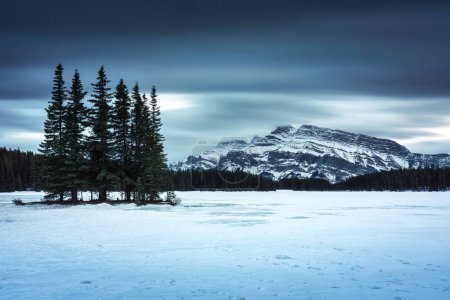 Téléchargez les photos : Vue spectaculaire du lac Two Jack avec mont Rundle et forêt de pins en hiver le soir au parc national Banff, Alberta, Canada - en image libre de droit