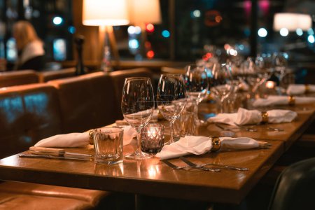 Téléchargez les photos : Restaurant rétro longue table à manger avec argenterie et verre à vin pour la restauration dans un restaurant luxueux - en image libre de droit