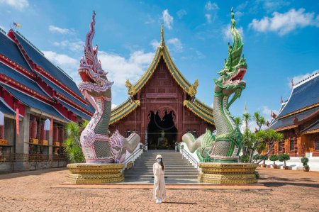 Photo for Asian female tourist come to worship at Wat Ban Den or Wat Den Salee Sri Muang Gan the Lanna style temple and colorful statue sculpture in sunny day at Chiang Mai, Thailand - Royalty Free Image