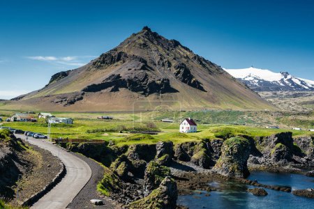 Belle vue sur le village de pêcheurs d'Arnarstapi avec la montagne Stapafell et la formation de roches de basalte sur le littoral de la péninsule de Snaefellsnes en Islande