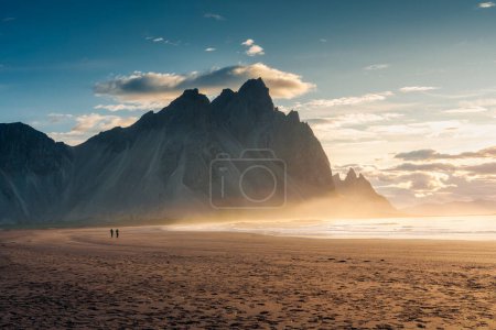 Photo for Breathtaking view of Vestrahorn mountain during sunrise and tourist standing on black sand beach in Stokksnes headland peninsula on summer at Iceland - Royalty Free Image