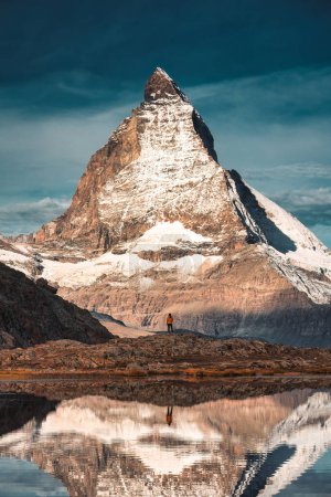 Photo for Majestic landscape of Matterhorn iconic mountain with tourist standing reflecs in Riffelsee lake at canton of Valais, Switzerland - Royalty Free Image
