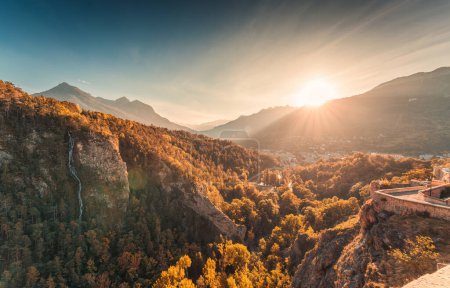 Photo for Beautiful sunset shines over old historical Briancon town with autumn forest and waterfall among the French Alps in Hautes Alpes, France - Royalty Free Image
