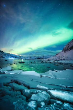 Hermoso paisaje de Aurora boreal, luces boreales que brillan sobre la montaña nevada en el océano ártico en las Islas Lofoten, Noruega
