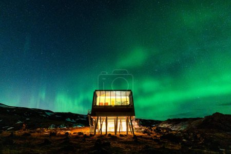 Schöne Aussicht auf Aurora borealis, Nordlichter, die im Winter über dem Luxushotel auf dem Berg Hengill in Nesjavellir, Island glühen