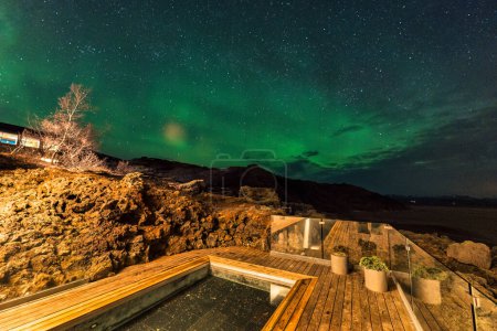 Schöne Aurora borealis, Nordlichter über dem Pool der heißen Quellen in einem Luxushotel in der Nacht