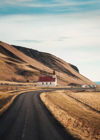 Beautiful autumn scenic of Reynisfjara Lutheran church with the road on the way to Reynisfjara beach in Vik, Iceland
