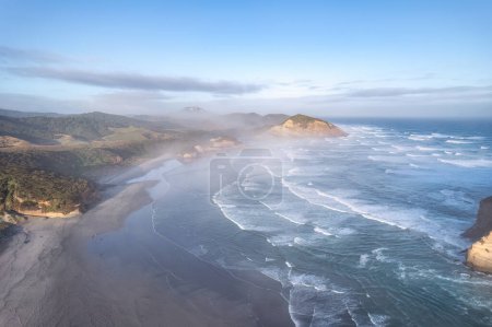 Aerial view of Picturesque sunrise shining over Wharariki beach and archway islands on Tasman sea at West of cape farewell, New Zealand