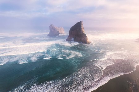 Aerial view of Picturesque sunrise shining over Wharariki beach and archway island on Tasman sea at West of cape farewell, New Zealand
