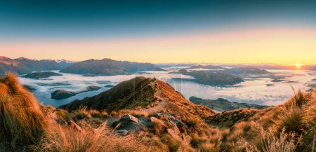 Atemberaubendes Sonnenaufgangspanorama über dem Gipfel des Roys Peak und dem nebligen Berg über dem Lake Wanaka im Herbst in Neuseeland