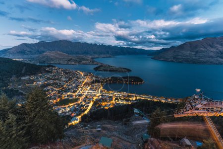Aerial view of Beautiful sunset sky over illuminated Queenstown with Lake Wakatipu and Skyline Gondola at New Zealand