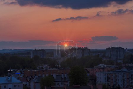 Soirée ville en été. Coucher de soleil sur la ville - Ostrowiec Swietokrzyski. La ville sous le soleil couchant au printemps. Immeubles d'appartements et divers bâtiments de la ville visibles.  