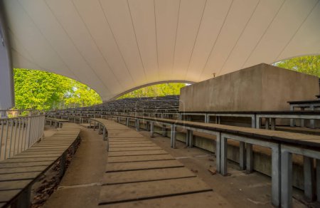 Vide sièges vides modernes pour un concert. auditorium couvert dans une salle de concert extérieure (ou stands de stade ! ?). Un après-midi de printemps dans un parc de la ville sous le toit d'une bande coquille.  