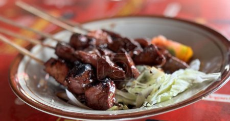 Sate kambing o cordero satay o carne de cabra satay servido con repollo en rodajas, tomates, salsa de soja dulce y chile, comida callejera indonesia