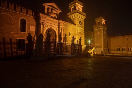 This is an image of the Arsenale, Venice, Italy. The image was taken from the left side and was shot at night when the structure and surrounding area was illuminated.