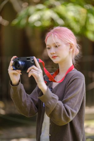 Beautiful woman with camera. Happy smiling woman taking photos of beautiful location. High Quality