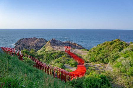 Motonosumi Inari Shrine in Yamaguchi prefecture, Japan. Red gates in front of the blue ocean. Photographed during a sunny summer day with blue sky and no clouds.