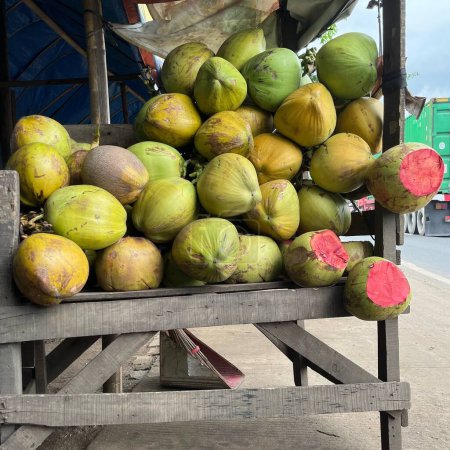 Red coconuts are sold on the side of the road