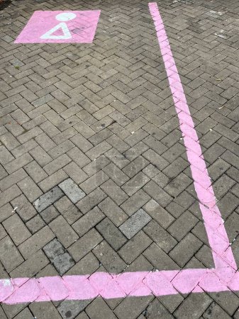 Pflastersteinparken mit einzigartigen rosafarbenen Parklinien und Symbol auf Rastplätzen