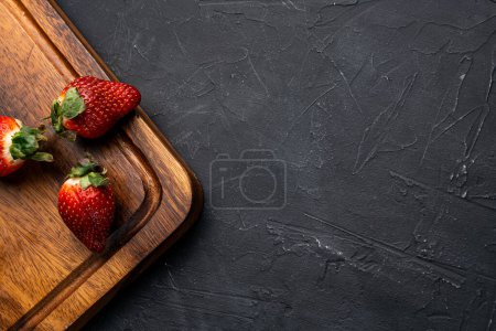 Top view image of a strawberry dish on a black background