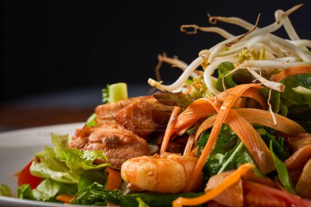 Téléchargez les photos : Photo rapprochée de salade de fruits de mer avec crevettes, saumon et légumes frais - en image libre de droit