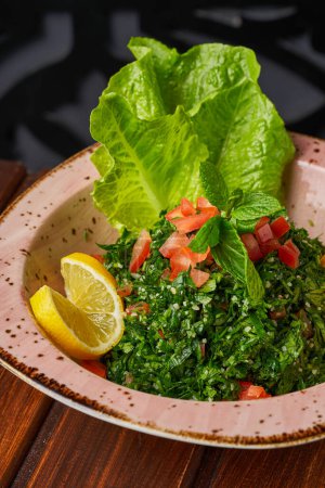 Nahaufnahme von syrischem Tabbouleh mit Salat, Petersilie, Tomate und Zitrone