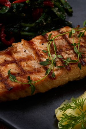 Téléchargez les photos : Une macro-pousse d'une assiette de saumon aux légumes bouillis sur un plancher de bois - en image libre de droit