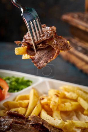 Foto de Una foto de un trozo de carne de shawarma siria en la punta de un tenedor - Imagen libre de derechos