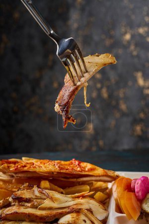 Foto de Una foto de un trozo de carne de shawarma siria en la punta de un tenedor - Imagen libre de derechos